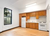 Thumbnail 6 of 22 - a kitchen with white appliances and wooden cabinets and a large window