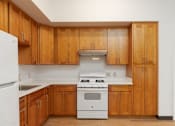 Thumbnail 2 of 22 - a kitchen with wooden cabinets and a white stove