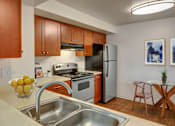Thumbnail 3 of 6 - A kitchen with a stove, oven, refrigerator, and sink.