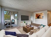 Thumbnail 4 of 6 - A living room with a white couch and a flat screen TV.