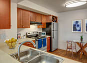 Thumbnail 5 of 6 - A kitchen with a stove, oven, refrigerator, and sink.