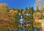 Thumbnail 5 of 18 - A fountain in the middle of a pond in front of a house.