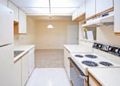 Thumbnail 9 of 18 - A kitchen with white appliances and cabinets.