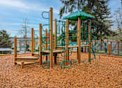 Thumbnail 13 of 18 - A playground with a green canopy and a wooden swing set.