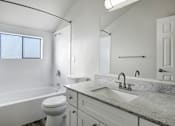 Thumbnail 27 of 31 - A white bathroom with a marble countertop and a window.