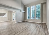 Thumbnail 28 of 31 - A spacious room with wooden flooring and large windows.
