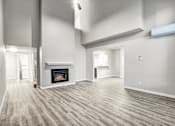 Thumbnail 31 of 31 - A spacious living room with a fireplace and hardwood floors.
