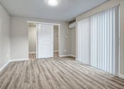 Thumbnail 29 of 31 - A room with a white door and a window with white blinds.