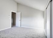 Thumbnail 21 of 31 - A room with a carpeted floor and a white door.