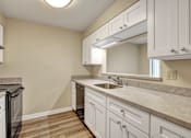 Thumbnail 15 of 16 - A kitchen with white cabinets and a marble countertop.