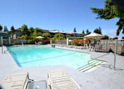 Thumbnail 1 of 6 - A swimming pool surrounded by a fence and trees.