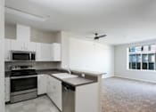 Thumbnail 36 of 40 - an empty kitchen with white cabinets and stainless steel appliances