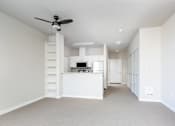 Thumbnail 35 of 40 - an empty living room with a kitchen and a ceiling fan