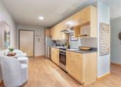 Thumbnail 11 of 20 - A kitchen with wooden cabinets and a white chair.