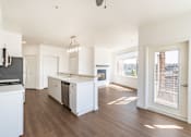 Thumbnail 40 of 40 - A kitchen with white appliances and wooden floors.