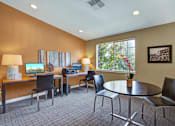 Thumbnail 8 of 16 - A conference room with a table, chairs, and a vase of flowers.