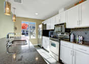 Thumbnail 11 of 16 - A kitchen with white cabinets and a black stove top oven.