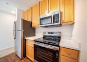 Thumbnail 10 of 27 - A kitchen with wooden cabinets and a stainless steel refrigerator.
