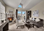Thumbnail 16 of 16 - A modern living room with a stone fireplace and a skylight.