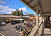 Thumbnail 6 of 16 - A parking lot with cars and a building in the background.