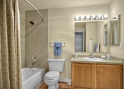 Thumbnail 3 of 16 - A bathroom with a toilet, sink, and shower.