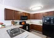 Thumbnail 7 of 20 - photo of kitchen with black refrigerator, black microwave and black stove