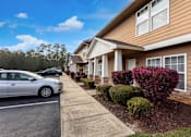 Thumbnail 2 of 12 - a car parked in a parking lot in front of a house