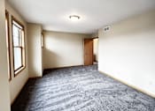 Thumbnail 10 of 30 - A room with a carpeted floor and a door.