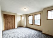 Thumbnail 9 of 30 - A room with a carpeted floor and a door.