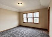 Thumbnail 8 of 30 - A room with a carpeted floor and a window.