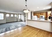 Thumbnail 1 of 30 - A kitchen with wooden floors and white appliances.