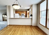 Thumbnail 4 of 30 - A kitchen with wooden floors and white walls.