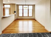 Thumbnail 6 of 30 - A room with wooden floors and a large window.