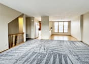 Thumbnail 12 of 30 - A large, empty room with a carpeted floor and a window.