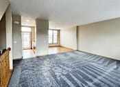 Thumbnail 14 of 30 - A spacious room with a blue carpet and wooden railings.