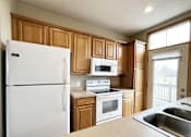 Thumbnail 16 of 30 - A kitchen with wooden cabinets and white appliances.