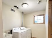 Thumbnail 28 of 30 - A small bathroom with a washer and dryer.