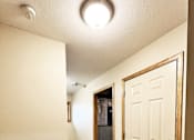 Thumbnail 21 of 30 - A hallway with a tiled floor and a white door.