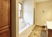 Thumbnail 17 of 30 - A bathroom with a tub, toilet, and sink.