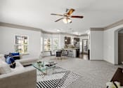 Thumbnail 29 of 59 - a living room with a couch a table and a ceiling fan at Stonepost Crossing Apartments, Overland Park, 66213