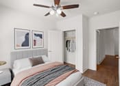 Thumbnail 8 of 23 - A bedroom with a ceiling fan, clothes closet, and hardwood floors at Mirabelle Luxury Apartments, Kansas City, MO, 64111