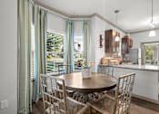 Thumbnail 4 of 59 - a dining room with a table and chairs and a kitchen in the background at Stonepost Crossing Apartments, Overland Park, KS, 66213