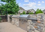 Thumbnail 56 of 59 - A stone wall with a grill on top at Stonepost Crossing Apartments, Overland Park, KS, 66213