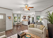 Thumbnail 1 of 59 - a living room with a couch a table and a ceiling fan at Stonepost Crossing Apartments, Overland Park