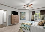 Thumbnail 17 of 59 - a bedroom with a bed and a ceiling fan at Stonepost Crossing Apartments, Overland Park, KS