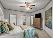 Thumbnail 18 of 59 - a bedroom with a bed and a ceiling fan at Stonepost Crossing Apartments, Overland Park, Kansas