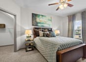Thumbnail 14 of 59 - a bedroom with a bed and a ceiling fan at Stonepost Crossing Apartments, Overland Park, Kansas