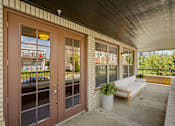 Thumbnail 32 of 50 - the porch of a building with a couch and a chair on it at The Dorset, Kansas City, 64112
