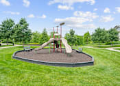 Thumbnail 57 of 59 - A playground with a slide and a red pole at Stonepost Crossing Apartments, KS