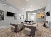 Thumbnail 46 of 59 - a living room with couches and a ping pong table at Stonepost Crossing Apartments, Overland Park, Kansas